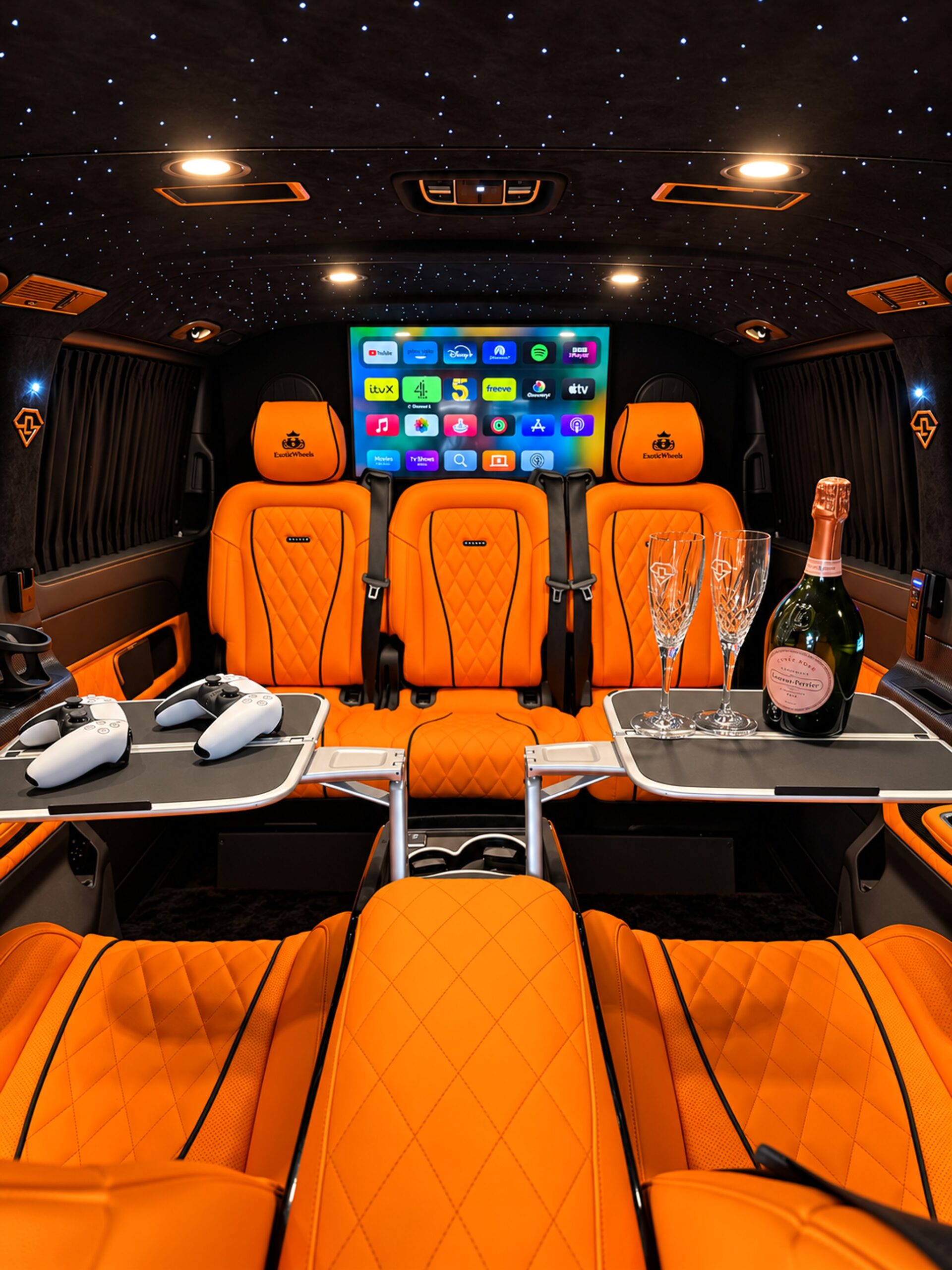 Mercedes-Benz V-Class cabin viewed from the rear, with orange leather seating, entertainment screen and ambient starlight roof